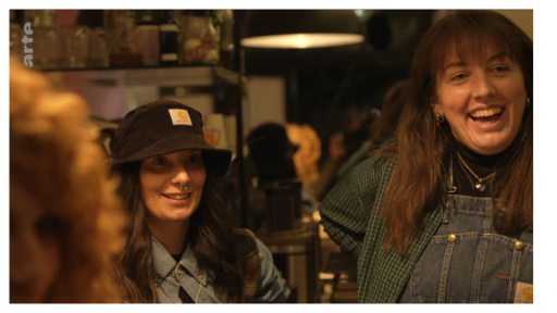 On voit deux jeunes femmes dans un bar. Elle rigolent.