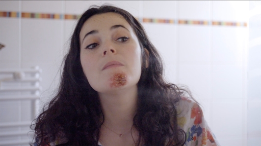 Inès observe attentivement, dans le miroir de sa salle de bain, la pustule apparue sur son menton.