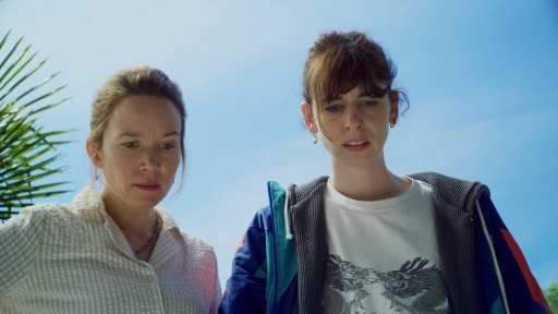 Anouck et Cécile regarde vers le bas, vers la balle de golf posée au sol.